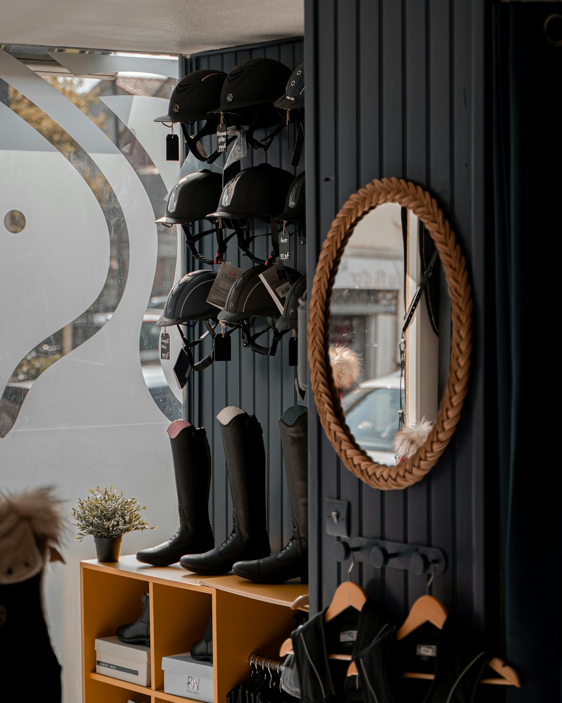 Cascos y botas de equitación negros expuestos en una tienda ecuestre.